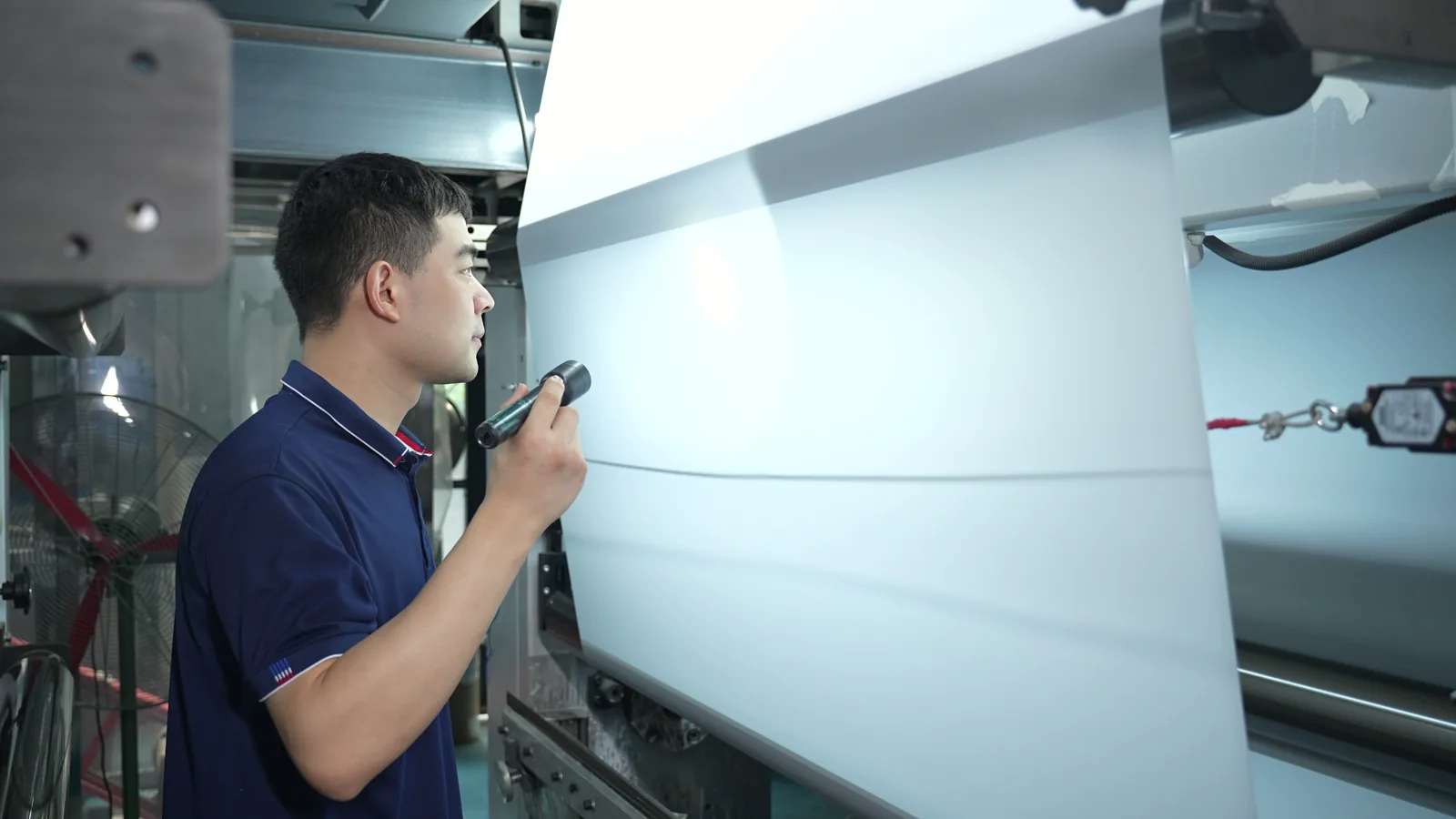 Jinlong worker inspecting DTF transfer film during production